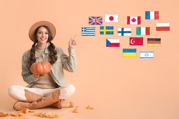 Beautiful woman with pumpkin and different flags on beige background. Studying of foreign languages