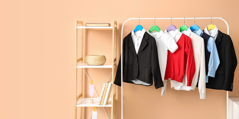 Shelf unit and rack with school uniform near color wall