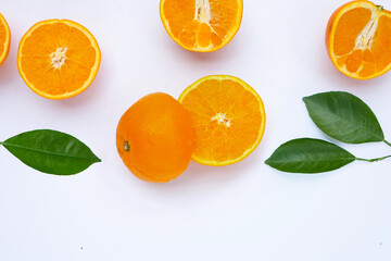 Orange fruit with green leaves on white background.