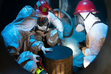 Worker cleaning internal pressure vessel in confine space.