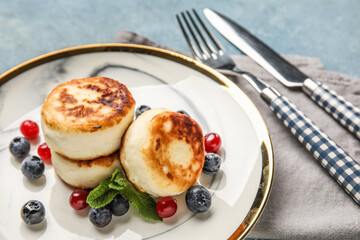 Plate with cottage cheese pancakes, cutlery and napkin, closeup