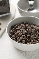Bowl of black cereal rings on table, closeup