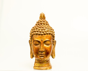 A beautiful hand-carved wooden Buddha head painted in gold isolated against a white background. 