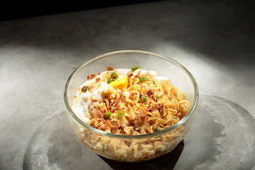 Noodles with egg toping, sprinkled with chopped green chilies and fried onions.