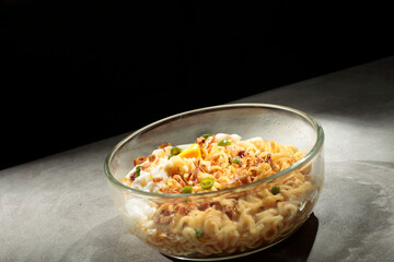 Noodles with egg toping, sprinkled with chopped green chilies and fried onions.