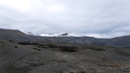 Snow capped hill above a volcanic landscape at Telefon Bay, Deception Island, Antarctica