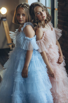 Happy teenage girls in beautiful dresses. Fashion friends, sisters. High quality photo