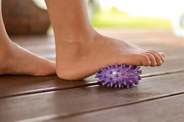 Myofascial relaxation of the muscles of the foot with a massage ball at home, close-up.