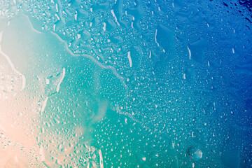 Water drops on glass, blue beige gradient. Concept of sea of relaxation. Abstract summer background