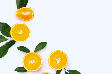 Orange fruit with green leaves on white background.