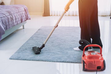 housewife cleaning dust the house Vacuum the carpet in the bedroom in the morning. maid using...