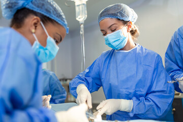 Team of professional doctors performing operation in surgery room. Medical Team Performing Surgical...