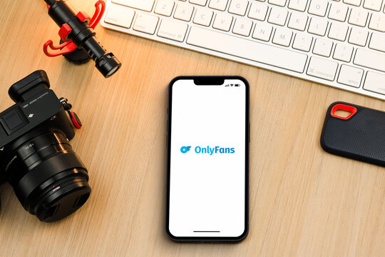 OnlyFans app on smartphone iPhone screen on wooden table. Content creator environment with keyboard, camera and mic. Rio de Janeiro, RJ, Brazil. July 2022