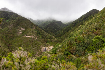 Fototapeta na wymiar Panoramic view on the cloud covered mountains of Anaga massif between Afur and Taganana on Tenerife, Canary Islands, Spain, Europe, EU. Hill landscape in UNESCO Anaga biosphere park. Tropical forest