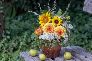 Blumenstrauß mit orange Dahlien und Sonnenblumen in Holzbierkrug