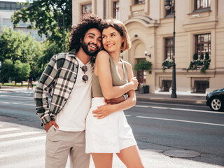 Smiling beautiful woman and her handsome boyfriend. Sexy cheerful multiracial family having tender moments in the street at sunset. Multiethnic models hugging. Embracing each other.Love concept