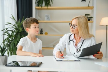 Healthcare for children: Little boy talking to doctor during visit to hospital.
