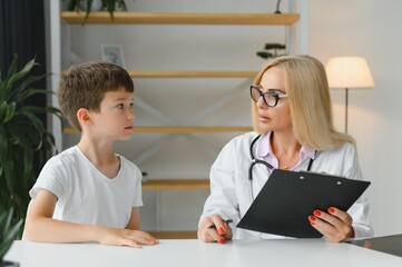 Obraz premium Healthcare for children: Little boy talking to doctor during visit to hospital.