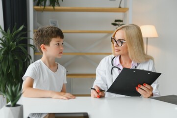 Healthcare for children: Little boy talking to doctor during visit to hospital.