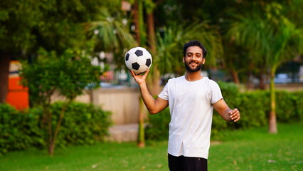 man celebrating victory and holding soccer ball.