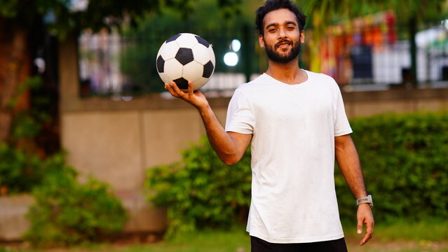 Excited happy young bearded man with football