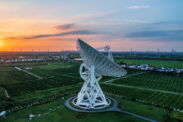 Aerial view of astronomical radio telescope and beautiful sky clouds at sunset