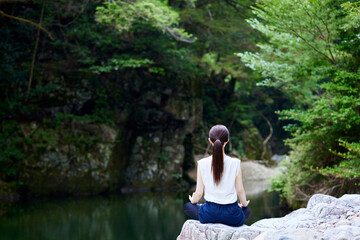 自然の中でストレッチを行う日本人女性