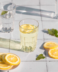 Fresh summer cocktail with lemons and mint. Summer drinks and vacation concept. Sunny day shadows