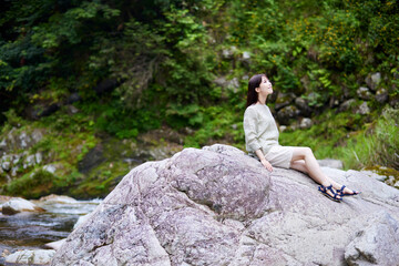 自然の中でリラックスする日本人女性