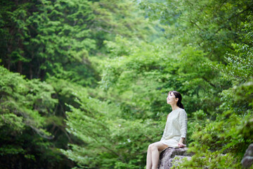 Naklejka na ściany i meble 自然の中で読書をする日本人女性