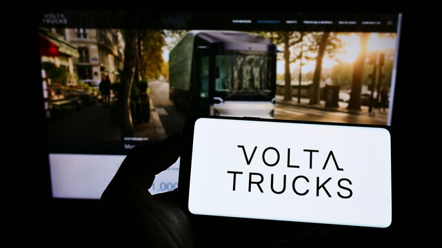 Stuttgart, Germany - 01-15-2022: Person holding mobile phone with logo of Swedish automotive company Volta Trucks AB on screen in front of web page. Focus on phone display.