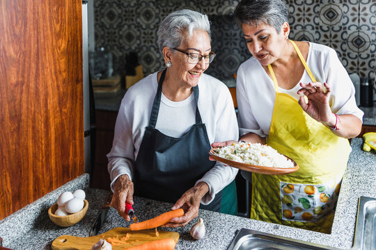 Hispanic women grandmother and daughter cooking at home kitchen in Mexico Latin America