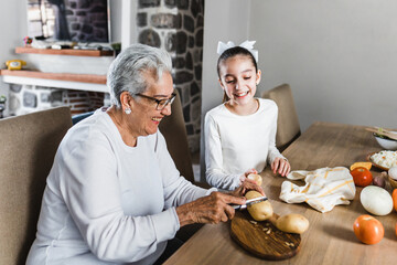 Hispanic grandmother and granddaughter cooking at home  in Mexico Latin America