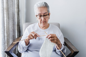hispanic Grandmother knitting at home in Mexico Latin America