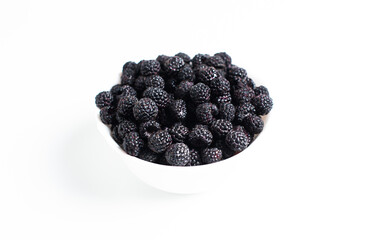 Blackberries in a white plate on a white background