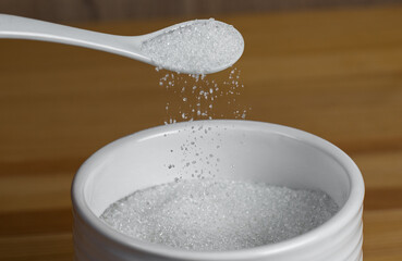 Kitchen set is sugar with a spoon on a wooden table