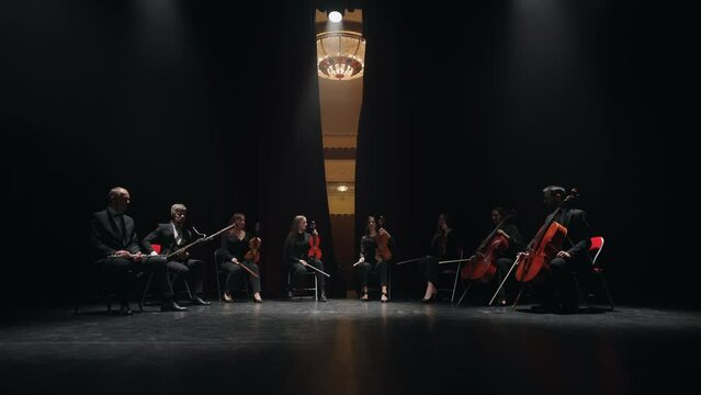 musical band of cello, violin, bassoon and flute playing on scene of opera house, curtains opening