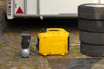 The compressor is connected to the petrol generator. Four car wheels.