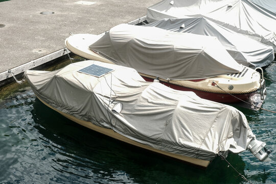 A picture of boat been covered with solar panel cover at the lake.