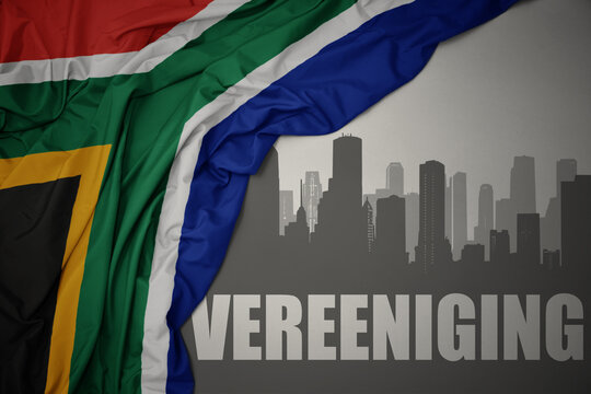 abstract silhouette of the city with text Vereeniging near waving colorful national flag of south africa on a gray background.