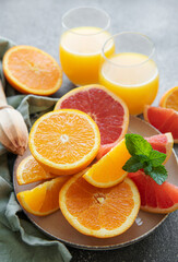 Glasses of juice and citrus fruits
