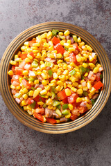 Spicy Sweet Corn Chaat in indian style served on a plate closeup on the table. Vertical top view from above