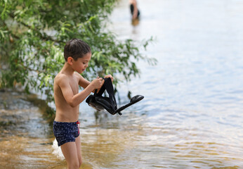 a boy on the shore with an underwater mask