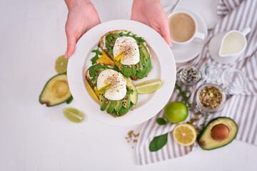 Freshly made poached egg and Avocado toasts on light grey background