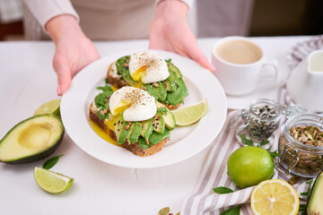 Freshly made poached egg and Avocado toasts on light grey background