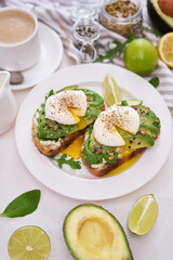 Freshly made poached egg and Avocado toasts on light grey background