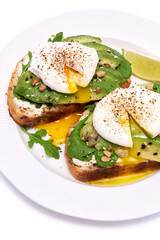 Freshly made poached egg and Avocado toasts isolated on white background