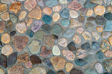 paved sidewalk with natural raw stones of different shapes and colors