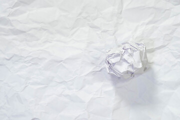 Crumpled ball on texture of white crumpled paper for background.