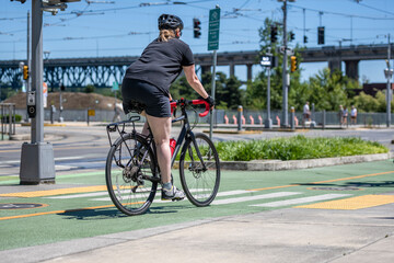 Overweight woman wants to lose weight and rides a bike on a bike path in a modern city